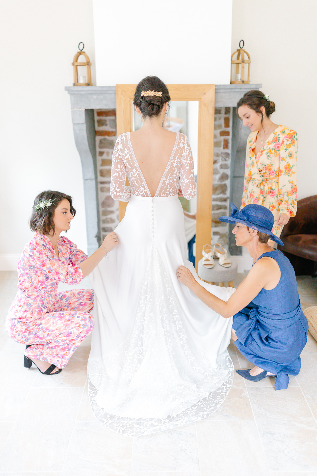 Les soeurs de la mariée ajustent sa robe