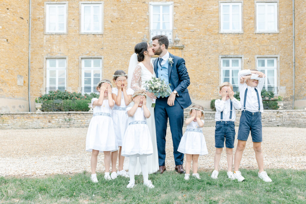 Les mariés s'embrassent entourés des enfants d'honneur