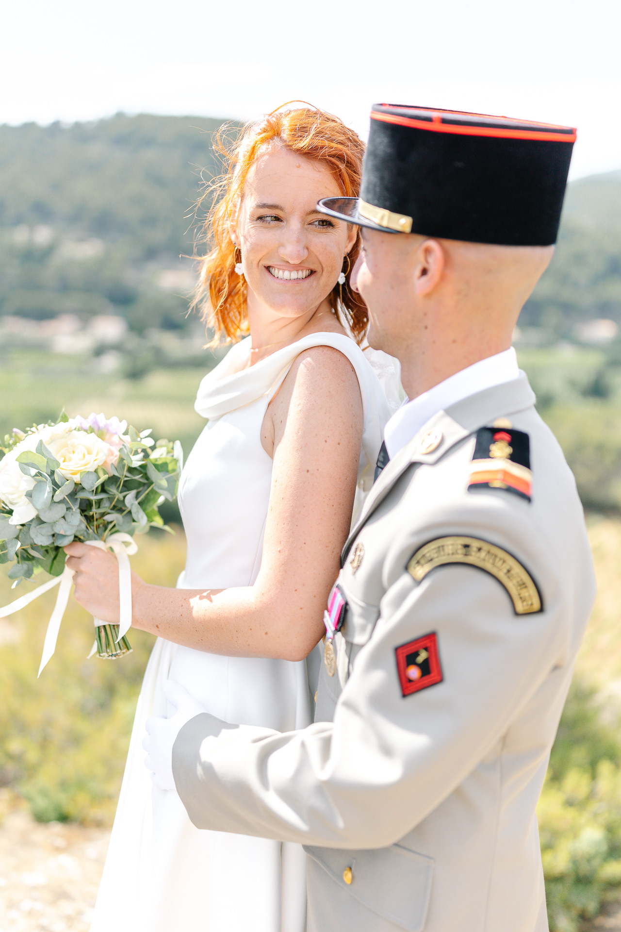 La marié regarde son mari en tenue officielle de militaire