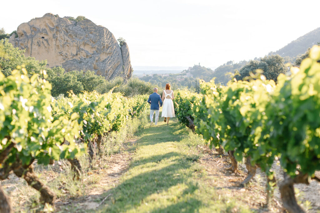 Des mariés marchent entre les vignes