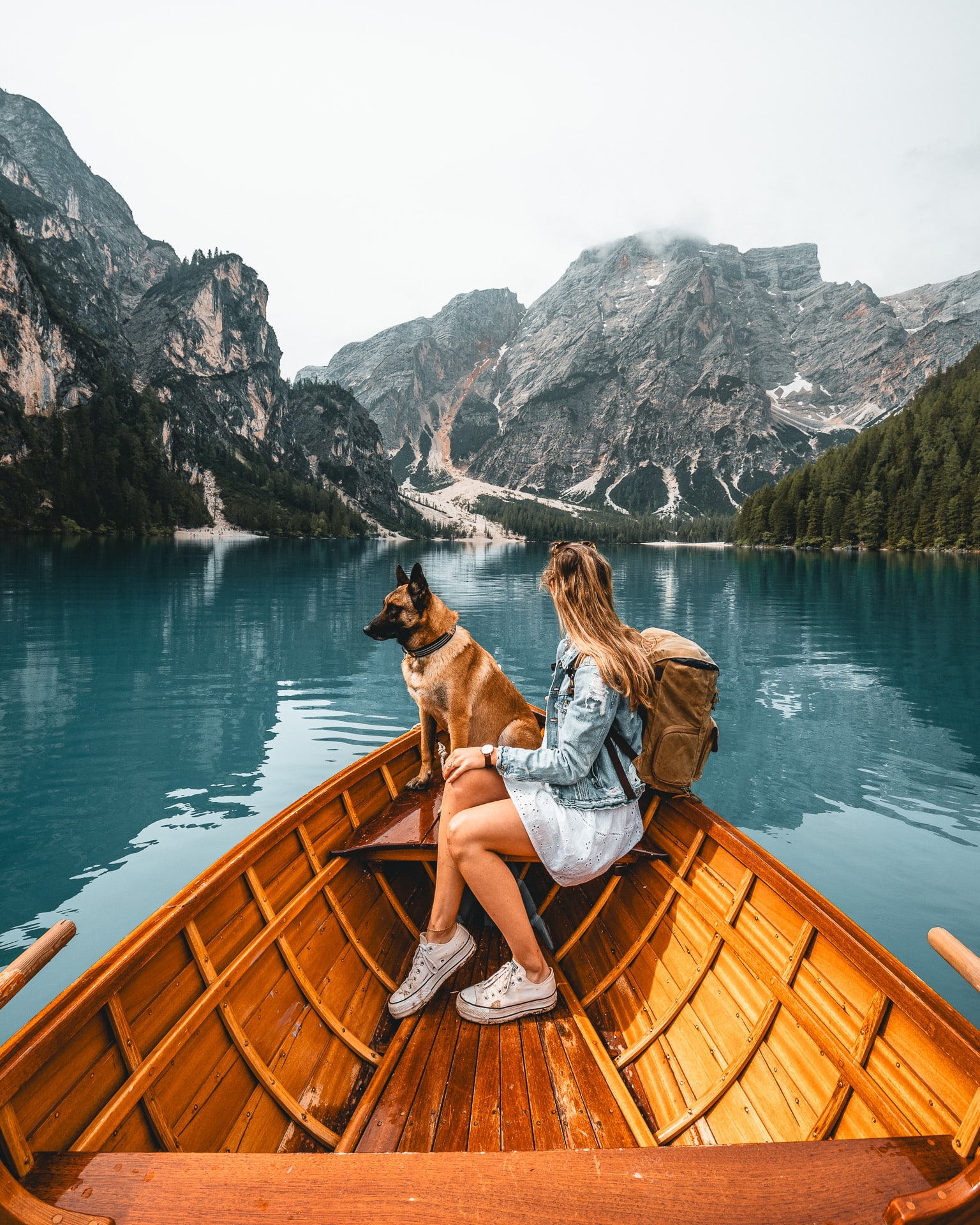 Une femme et un chien sur une barque en bois sur un lac