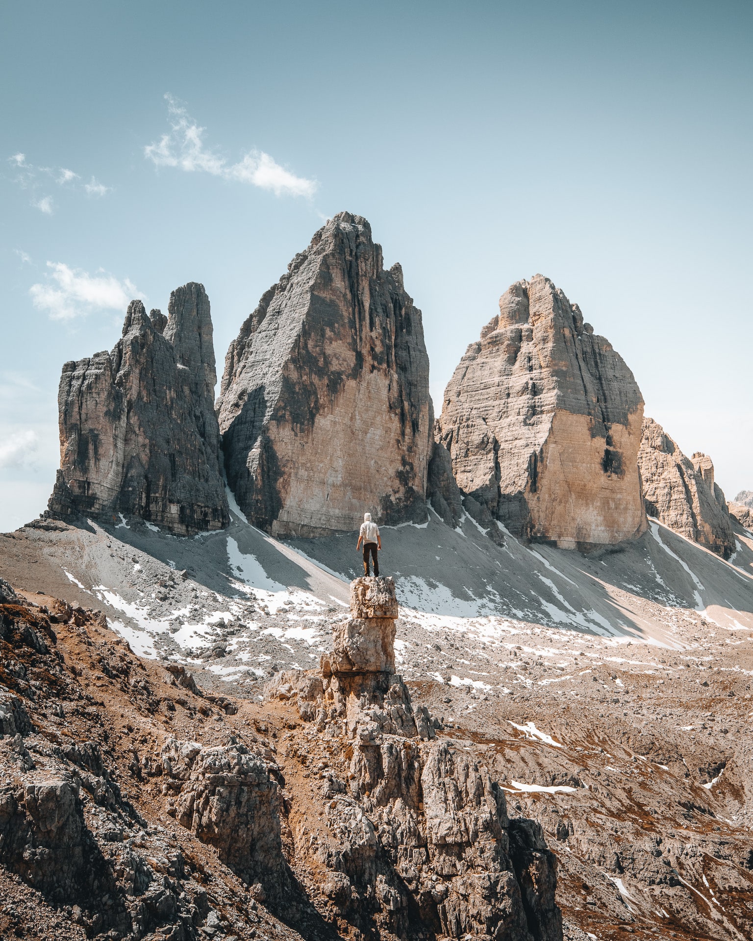 Un homme se tient face au Tre Cime dans les dolomites