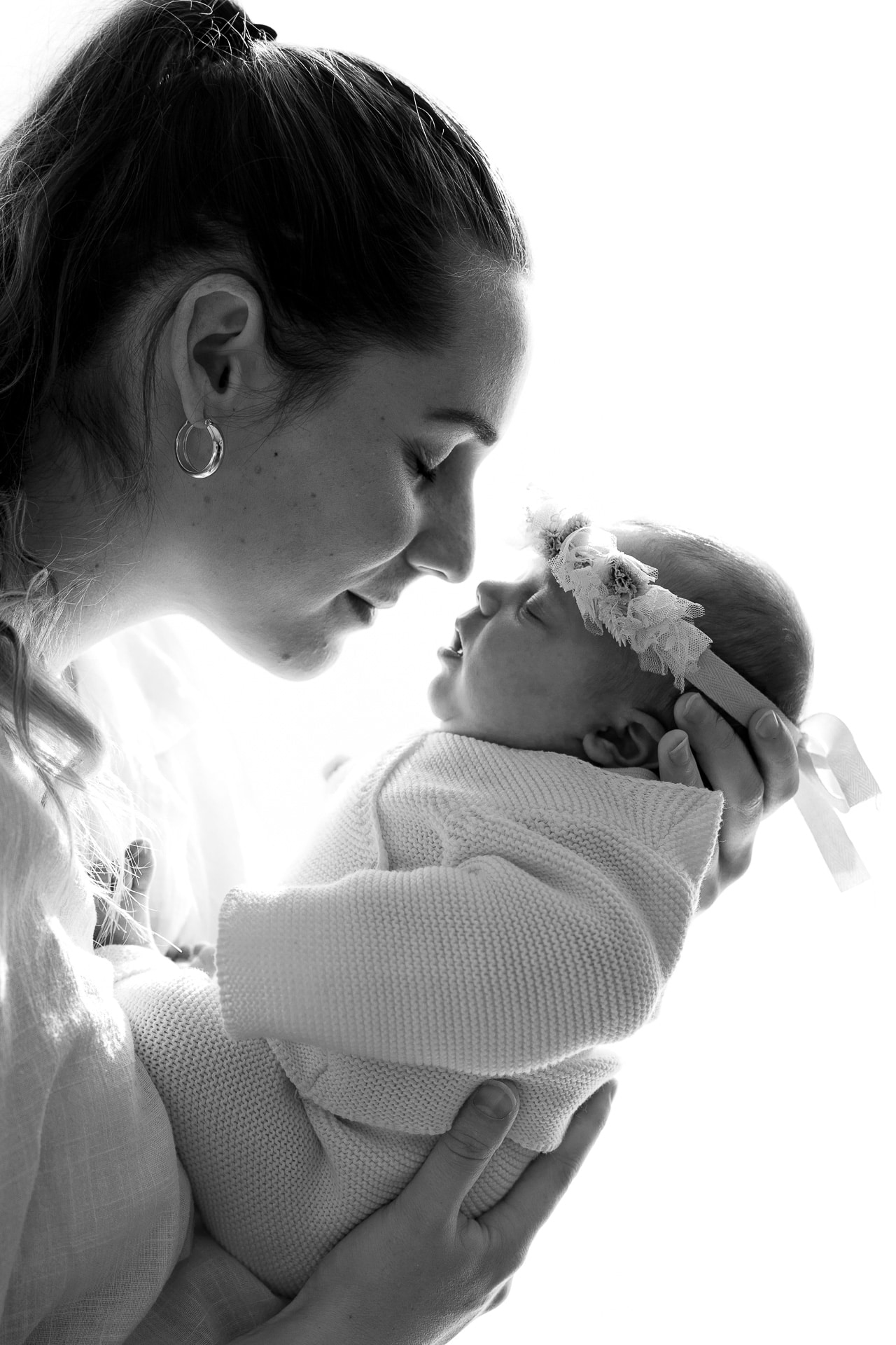 Une mere tient sa fille face a son visage, elles sont de profil